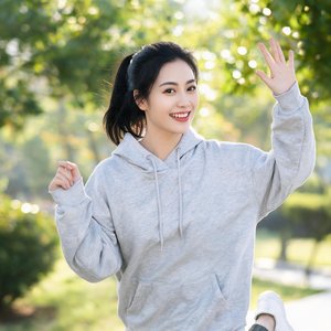 一位30岁左右的女性，扎马尾，穿休闲卫衣，充满活力